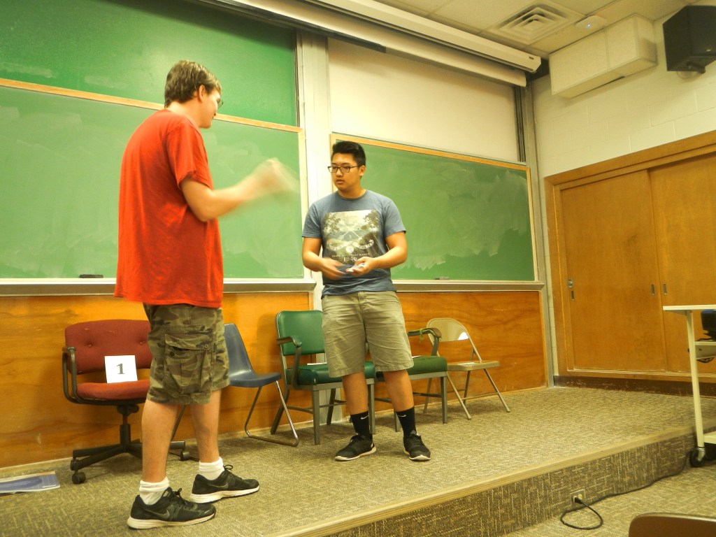 Photo: Austin Baucom, a sophomore biochemical engineering major, shakes his card to let the magic work, while Justin Le, a freshmen microbiology major, mixes a deck of cards to find the right one Saturday evening at student magician’s fundraiser show.