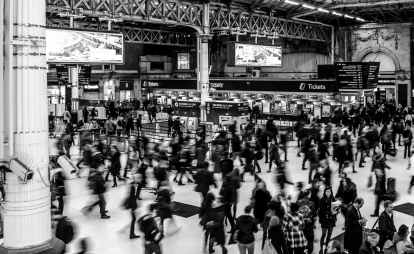 grayscale photography of people walking in train station