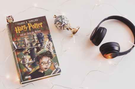harry potter book and black headphones with trinket